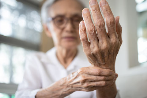 An old woman holding her wrist
